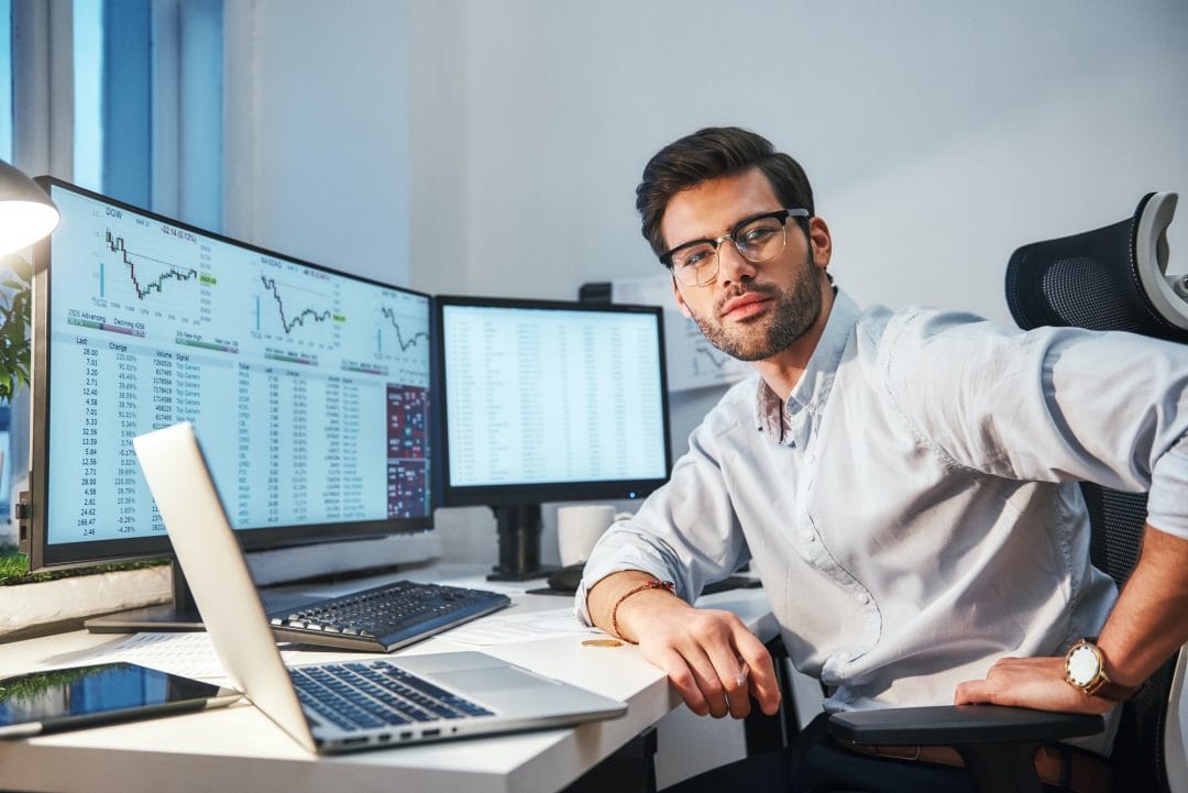 confident-and-smart-young-trader-or-businessman-in-eyewear-and-formal-clothes-is-looking-at-camera